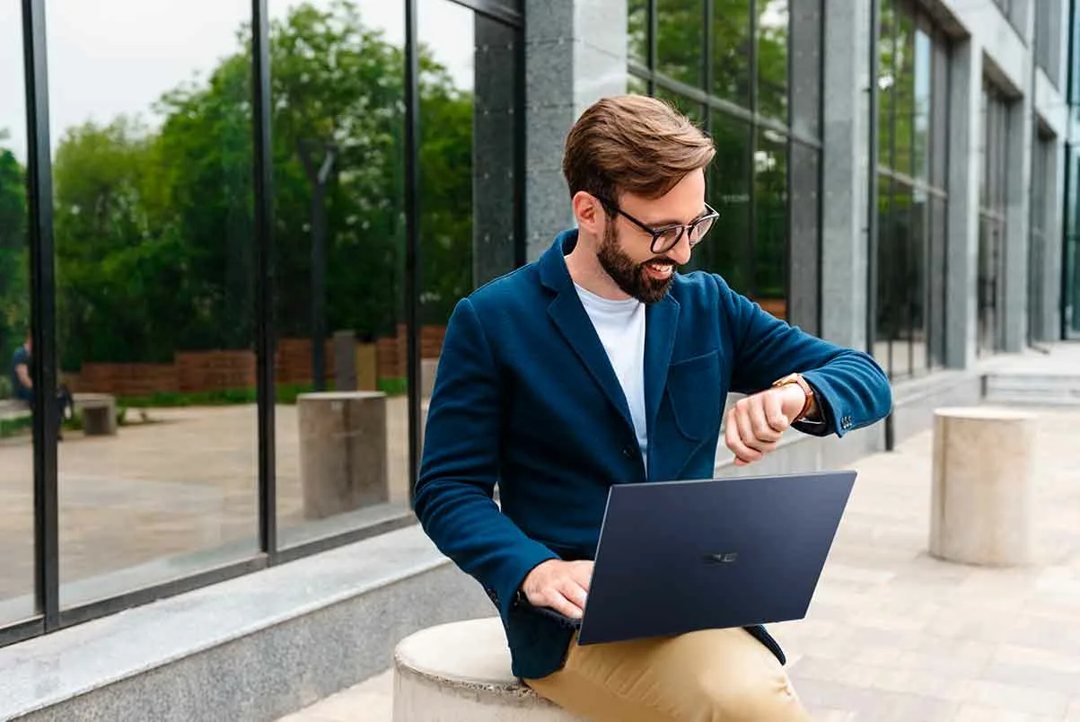 IT professional working on a laptop outside a modern office